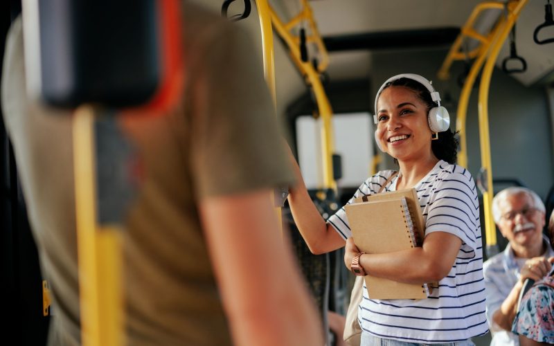 Women listening to music through headphones on the public bus.