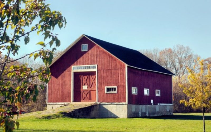 Historic red barn in green pasture.